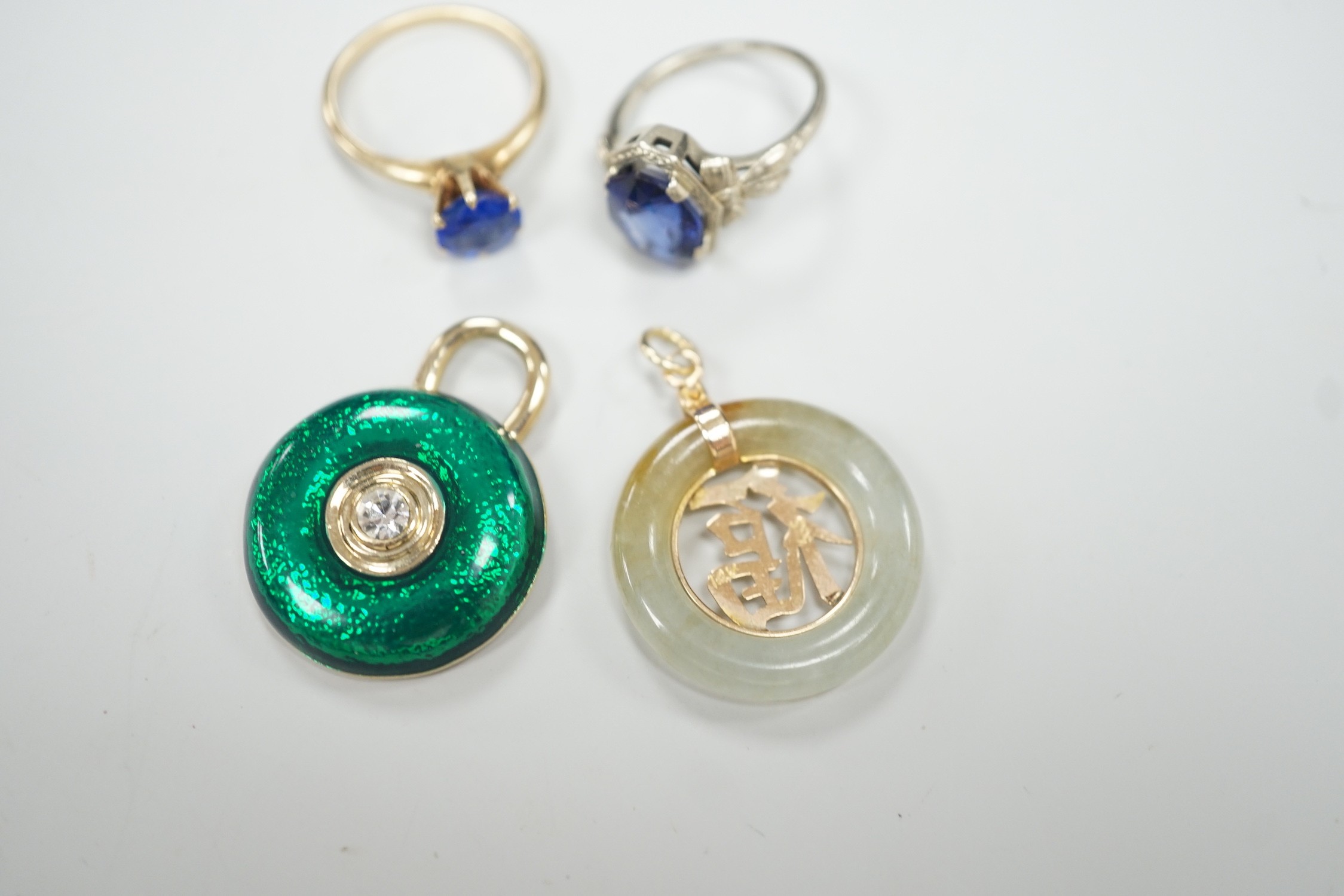 A 14k white metal and oval cut synthetic sapphire ring, a yellow metal and blue paste ring, a 585 yellow metal and jadeite pendant and a costume pendant.